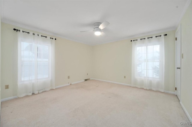 spare room with crown molding, light colored carpet, and ceiling fan