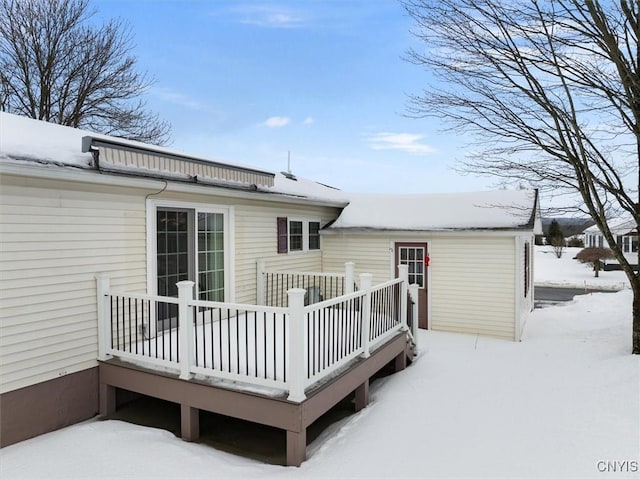 snow covered property with a wooden deck