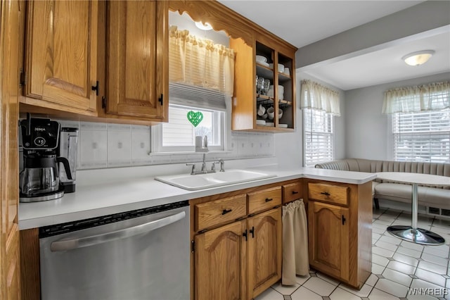 kitchen with sink, stainless steel dishwasher, decorative backsplash, and kitchen peninsula