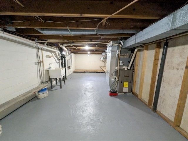 basement with heating unit and sink