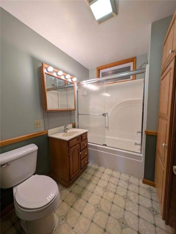 full bathroom with vanity, toilet, and combined bath / shower with glass door