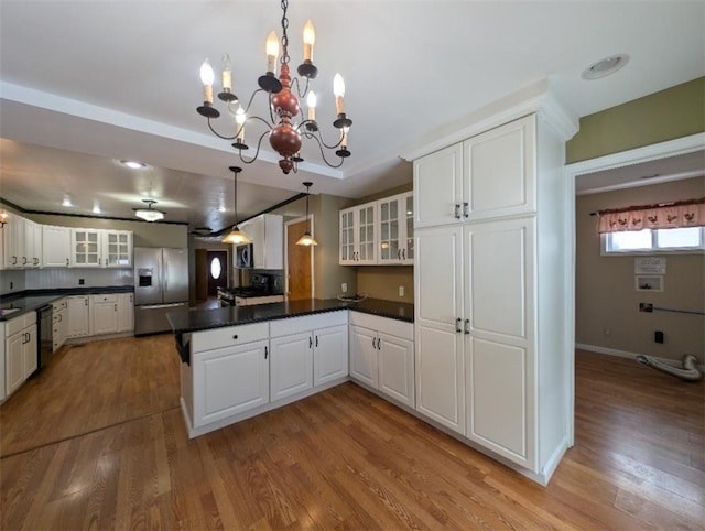 kitchen featuring hanging light fixtures, stainless steel refrigerator with ice dispenser, black dishwasher, and white cabinets