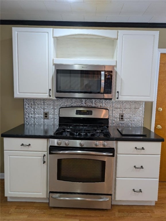 kitchen featuring tasteful backsplash, white cabinets, and appliances with stainless steel finishes