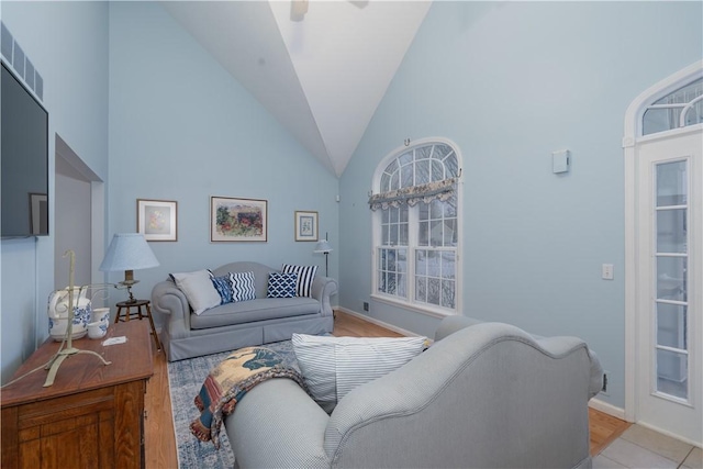 living room with high vaulted ceiling and light wood-type flooring