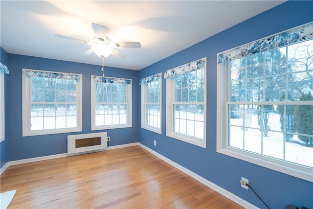 unfurnished sunroom featuring ceiling fan