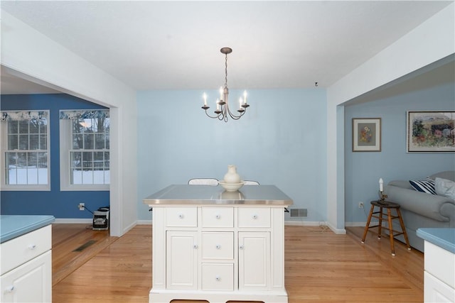 dining area with a chandelier and light wood-type flooring