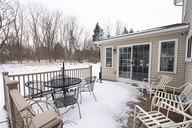 snow covered patio with a deck