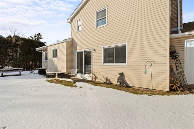 view of snow covered back of property