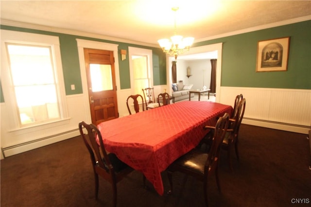 carpeted dining room with a baseboard radiator, ornamental molding, and a chandelier