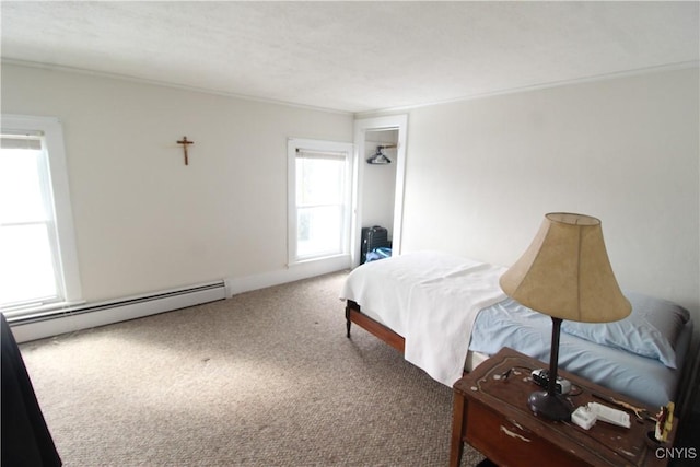 bedroom with carpet flooring and a baseboard heating unit