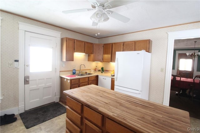 kitchen with crown molding, sink, ceiling fan with notable chandelier, and white appliances