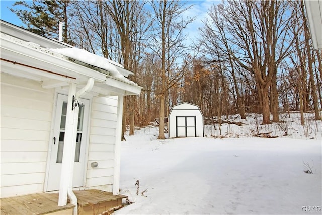 snowy yard featuring a storage unit