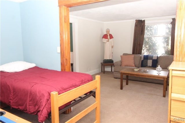 bedroom with ornamental molding and carpet