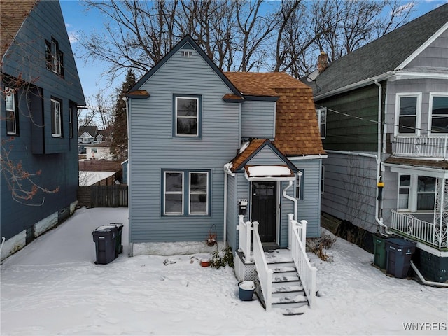 view of front of home featuring fence and roof with shingles