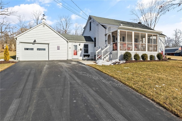 view of front facade with a garage, a sunroom, a porch, and a front yard