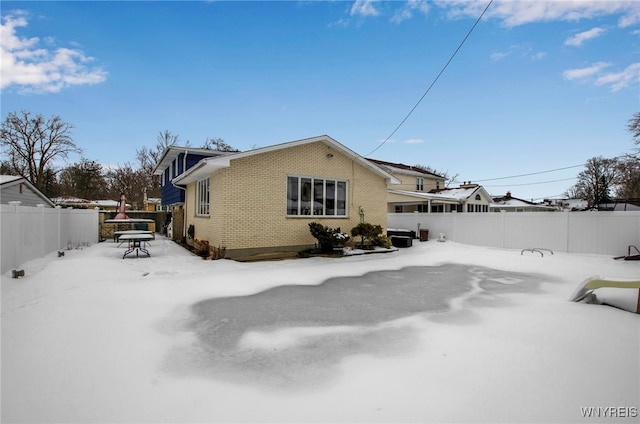 view of snow covered back of property