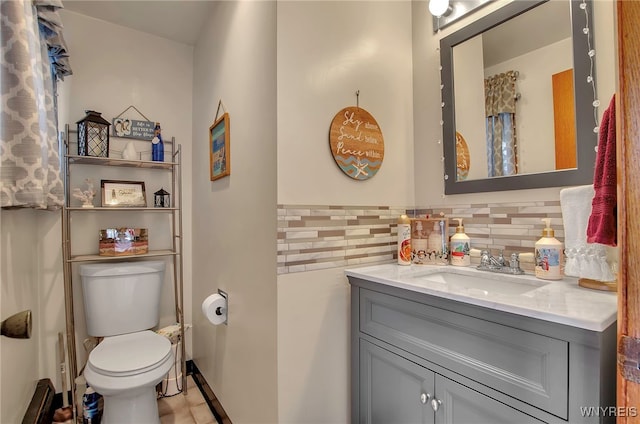 bathroom with vanity, backsplash, and toilet