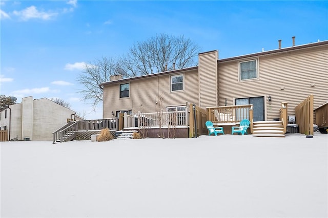 snow covered property with a deck