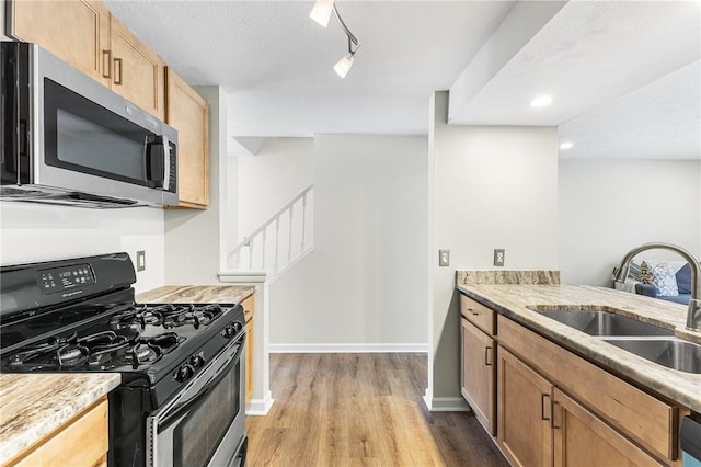 kitchen featuring light hardwood / wood-style flooring, sink, range with gas cooktop, and rail lighting