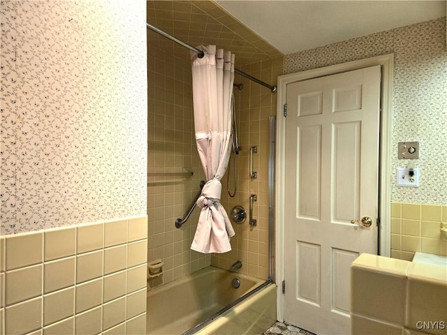 bathroom featuring tile walls and shower / tub combo with curtain
