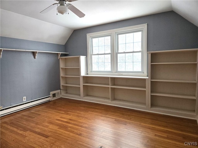 additional living space featuring wood-type flooring, lofted ceiling, ceiling fan, and baseboard heating