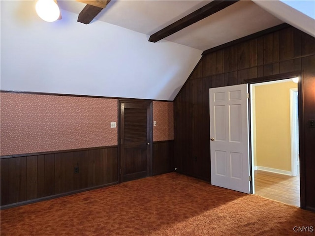 bonus room with light carpet, vaulted ceiling with beams, and wood walls
