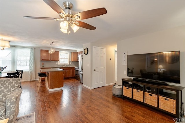 kitchen featuring dark hardwood / wood-style floors, tasteful backsplash, a kitchen breakfast bar, a center island, and ceiling fan