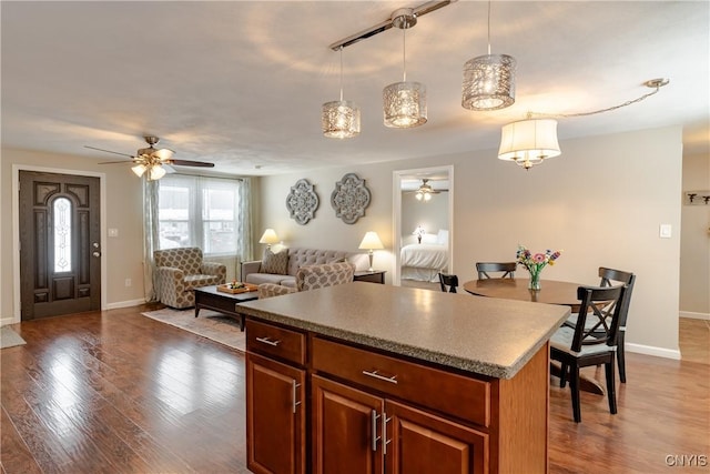 kitchen featuring a center island, hardwood / wood-style floors, ceiling fan, and decorative light fixtures