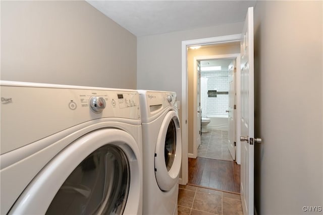 clothes washing area with light tile patterned floors and washing machine and dryer