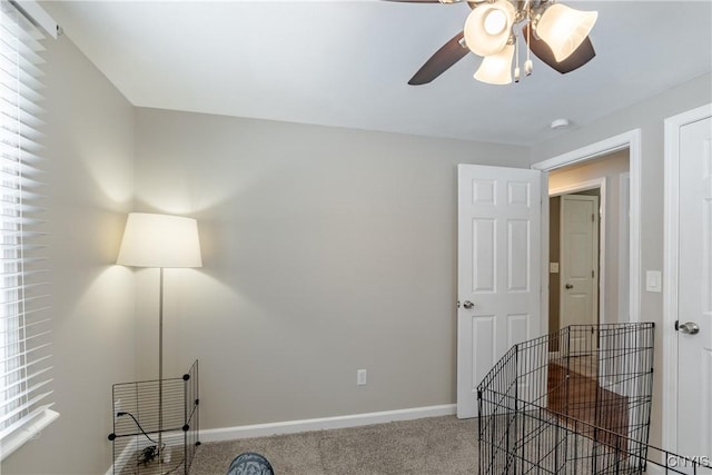 interior space with carpet floors and ceiling fan