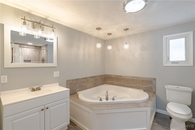 bathroom with vanity, a tub to relax in, and toilet