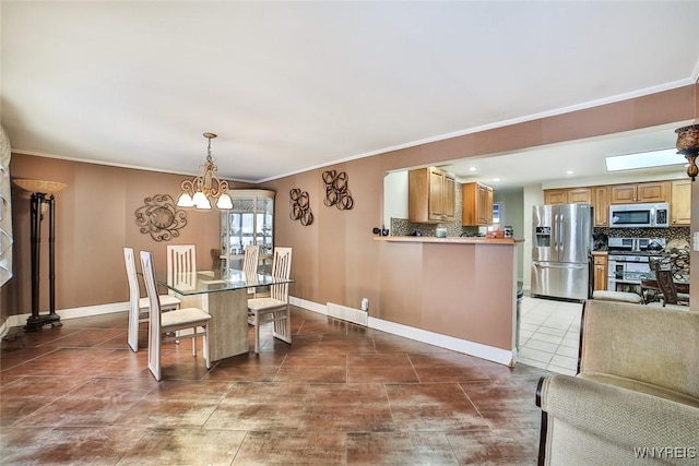 dining area featuring dark tile patterned floors, crown molding, and a notable chandelier