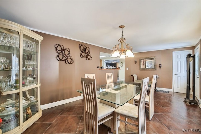 dining space with crown molding and a notable chandelier