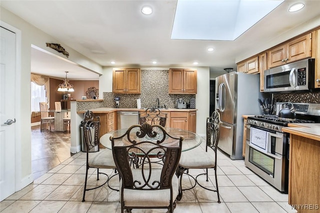 kitchen featuring stainless steel appliances, tasteful backsplash, sink, and pendant lighting