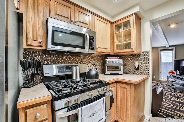 kitchen with decorative backsplash and appliances with stainless steel finishes