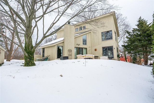 view of snow covered rear of property