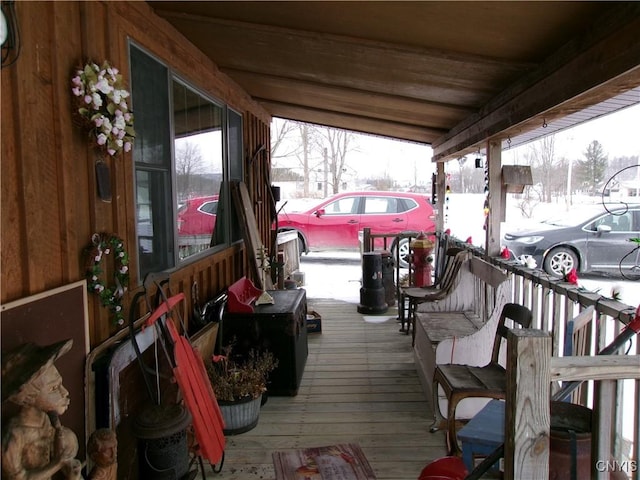 snow covered deck with a porch