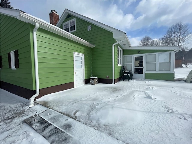 view of snow covered rear of property