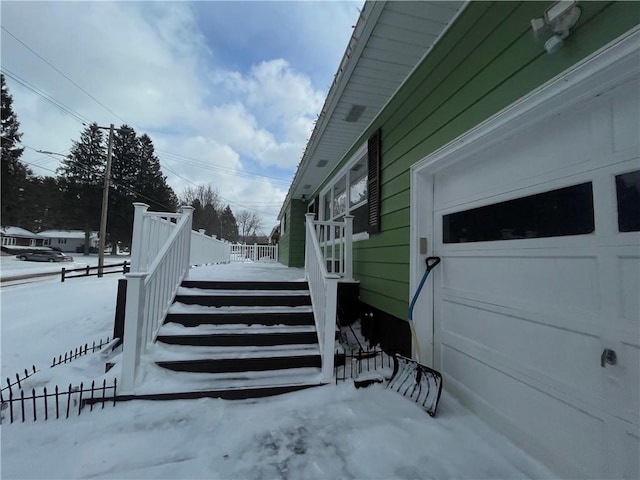 snow covered property with a garage