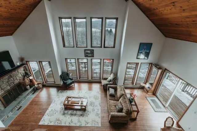 living room featuring wood-type flooring, wooden ceiling, and high vaulted ceiling