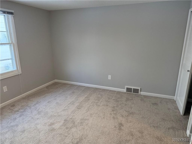 spare room featuring light colored carpet