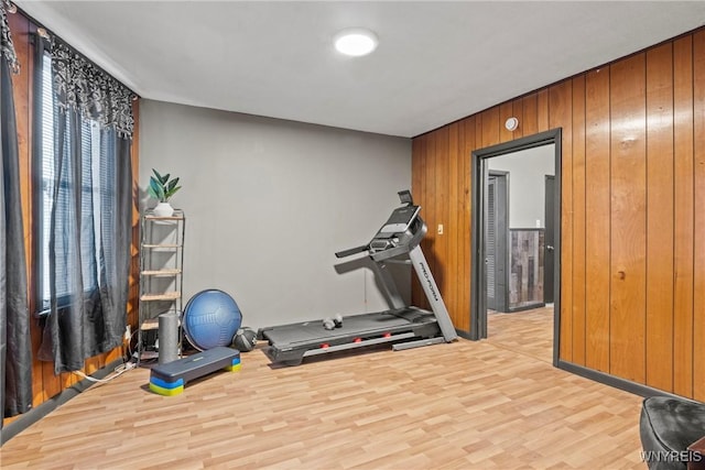 workout area with wooden walls and light hardwood / wood-style floors