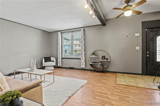 entryway with ceiling fan, hardwood / wood-style floors, and beam ceiling