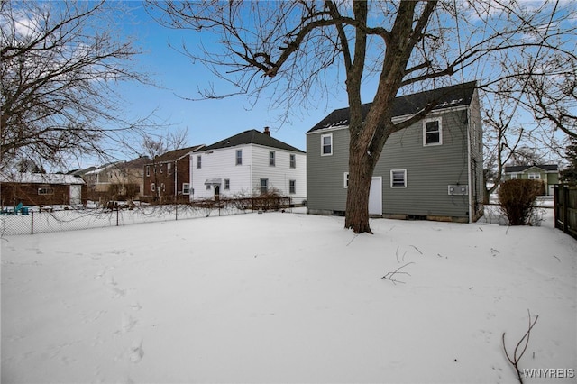 view of snow covered rear of property