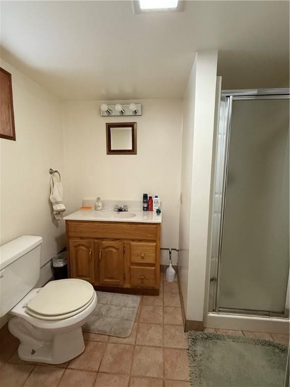 bathroom featuring tile patterned flooring, vanity, an enclosed shower, and toilet