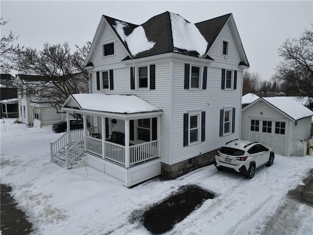 view of front of house featuring an outbuilding, a garage, and covered porch