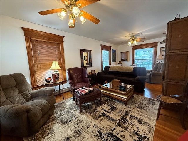 living room with a baseboard radiator, hardwood / wood-style floors, and ceiling fan