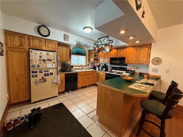 kitchen with light tile patterned floors, sink, black appliances, and kitchen peninsula