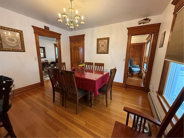 dining room featuring hardwood / wood-style floors, a chandelier, and baseboard heating