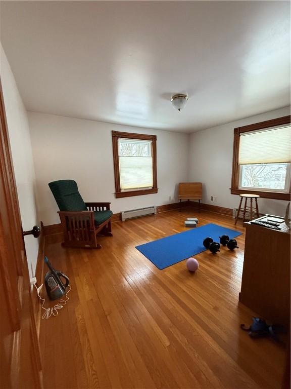 exercise area featuring a baseboard radiator and hardwood / wood-style floors